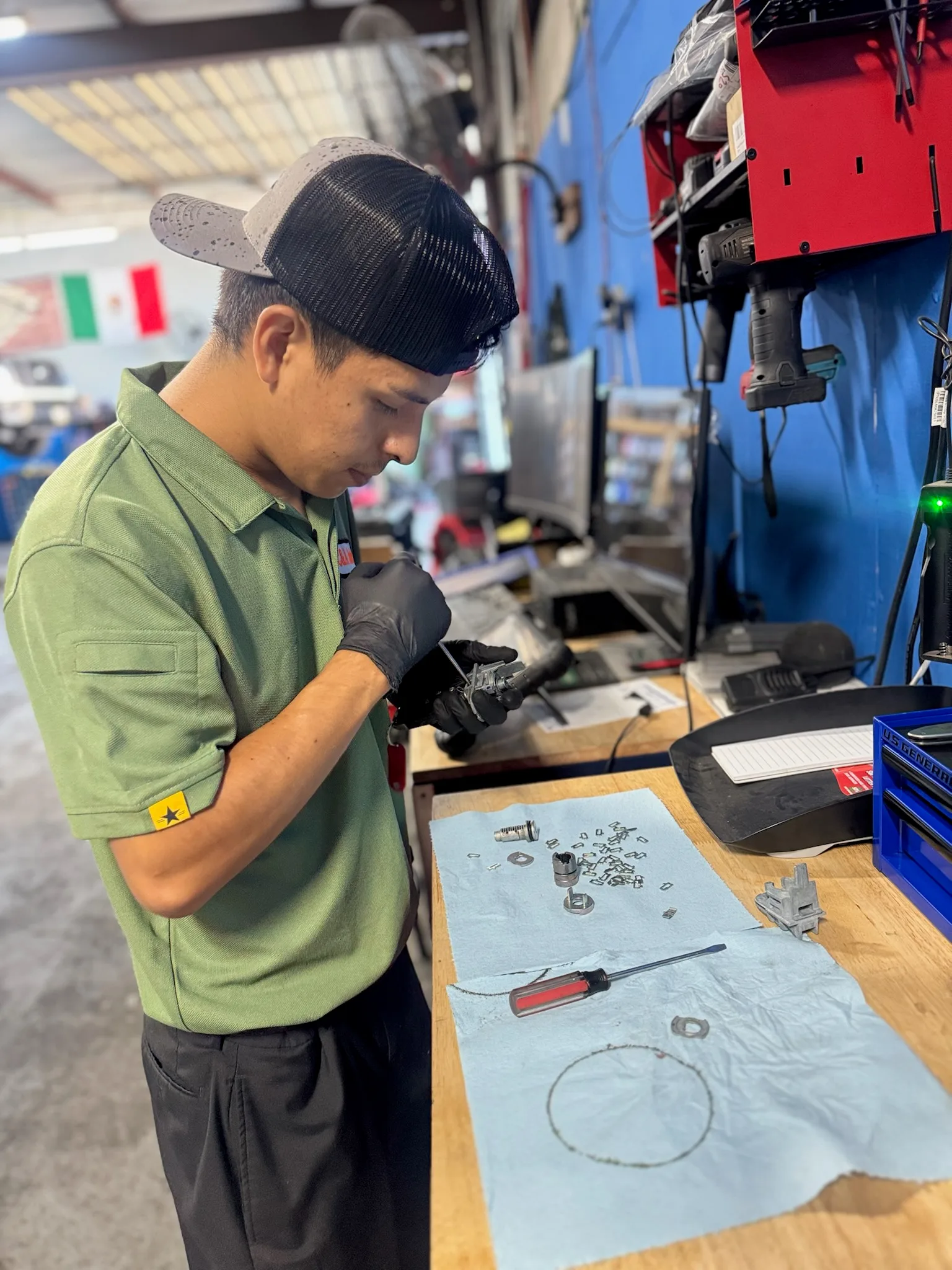 Technician at the workbench taking apart a component on a parts mat